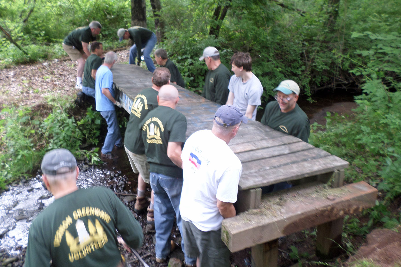 Move an eighteen foot five hundred pound bridge to a new site on the Hockanum River Linear Park Trail.